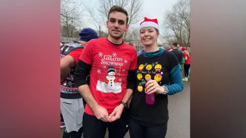 Pancreatic Cancer UK A man in a red top and a woman in a black top in a Santa hat.