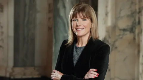 Belfast Chamber A woman with light hair, black blazer and white and black top