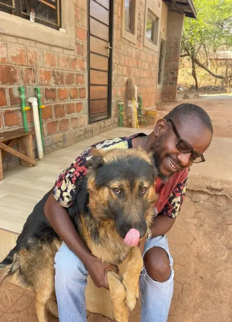 BBC / Kennedy Gondwe Kennedy com seu cachorro