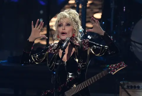 VALERIE MACON/AFP Inductee US singer-songwriter Dolly Parton performs during the 37th Annual Rock and Roll Hall of Fame Induction Ceremony at the Microsoft Theatre on November 5, 2022, in Los Angeles, California. 