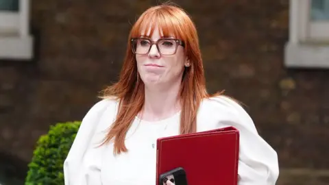 Angela Rayner pictured arriving in Downing Street wearing a white dress, carrying a red ministerial folder