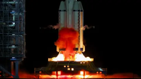 The Shenzhou 19 spacecraft lifting off, bright lights and smoke come from underneath