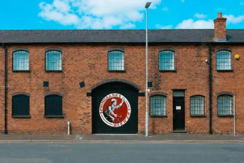 Springbanks Brewery Springbanks Brewery, with a red and black logo on a large black door, is a red-brick building with metal bars on the windows