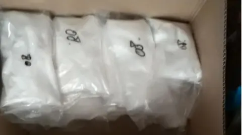 National Crime Agency A box full of bags of what appears to be cocaine.