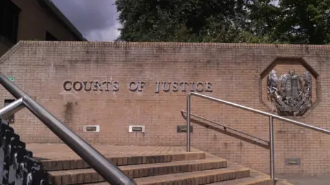 A general view of a wall outside a court with the words 'courts of justice' 