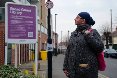 BBC Kiran Choda stands looking at the now closed Broad Green Library