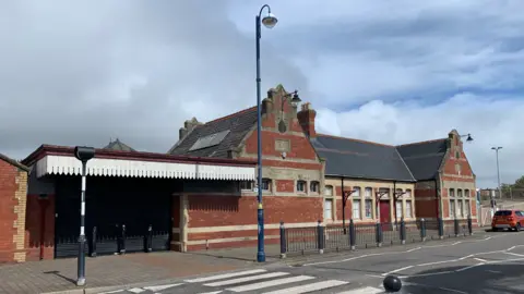 Barry's Victorian station from the outside, a red brick building, which haas recently been listed by Cadw