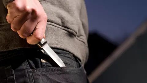 Getty Creative Man taking knife out of pocket