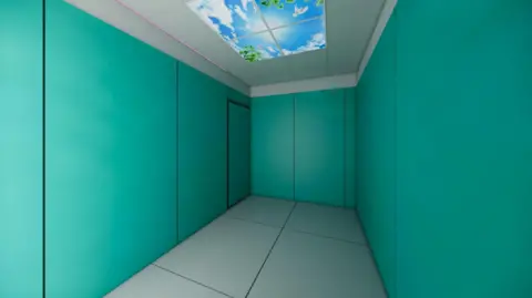 P+HS Architects Artist's impression of a planned quiet room - a sensory-controlled environment tailored specifically for autistic, neurodiverse, and learning-disabled children. It features padded walls in a shade of blue green, with a grey floor and ceiling, the latter having a large skylight with a digital image of blue sky with some clouds. It is empty of furniture.
