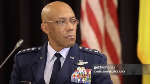 CQ Brown in navy blue uniform and glasses