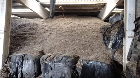 Environment Agency Brown waste piled to the ceiling in an industrial unit