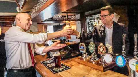 PA Prime Minister Andy Burnham and Chancellor John Healey in a pub