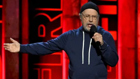 Getty Images Billy Crystal speaks onstage during the FIREAID Benefit Concert for California Fire Relief at The Kia Forum on January 30, 2025 in Inglewood, California