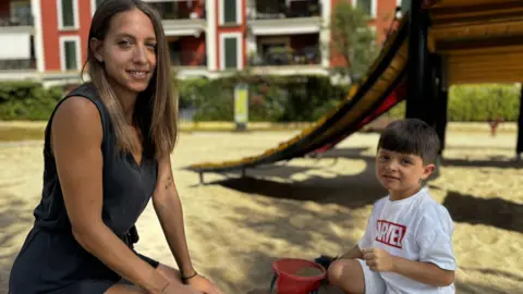 Sonia und ihr Sohn sitzen am Strand