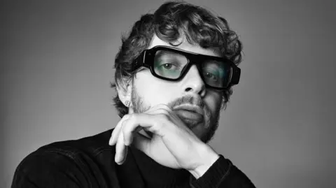 Snap Close up black and white photo of Jack Harlow wearing chunky black glasses