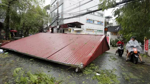 EPA A metal roof is seen on the street after strong winds blew it off the property