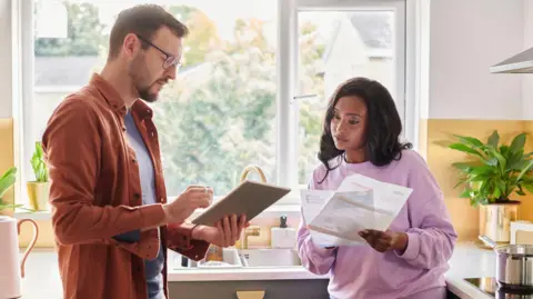 A couple looking at energy bills in their kitchen