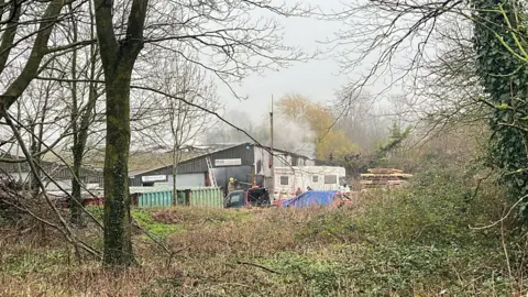 George Carden/BBC Humo saliendo de la parte trasera de un pequeño edificio industrial.