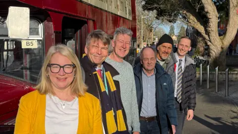 Sophie Law, Ian Loader, David Henwood, Graham O'Donnell and Lucke Marrion stood next to a vintage red bus.