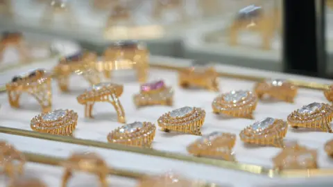 A box of rings with gold bands and coloured stones.