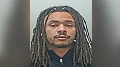 Andrew Phillips is staring directly at the camera and he has no expression on his face in his police mugshot. 