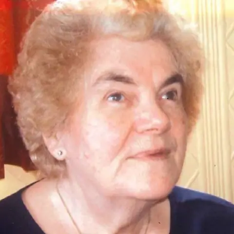 Police Scotland Margaret Hanson, wearing a acheronian  apical  and stud earrings, looks upwards. 