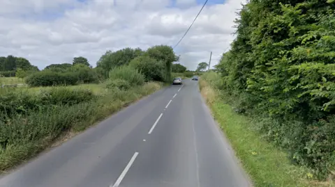 Rural tree-lined 40mph road in Worton, Wiltshire