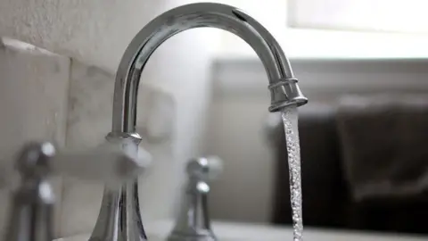 Water falls from a tap