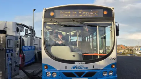 Luke Wilson Luke Wilson sitting in the drivers seat of a blue and white Ulsterbus. 