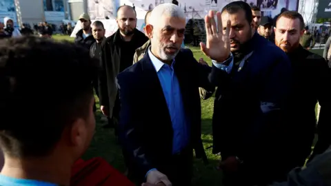 Op een bestandsfoto van Reuters is te zien hoe Hamas-leider Yahya Sinwar een man de hand schudt tijdens een bijeenkomst in Gaza op 14 april 2023.
