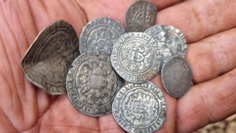 Eight silver coins in a hand