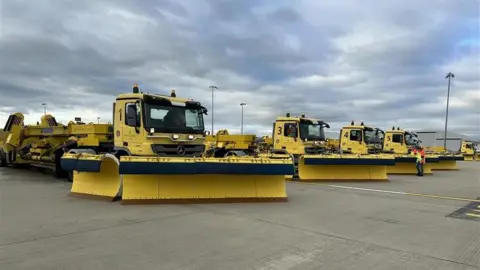 BBC A fleet of yellow snow ploughs at Gatwick Airport. 