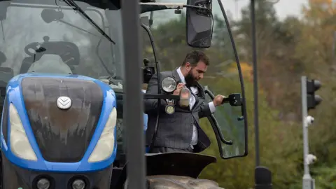 Pacemaker a man in a grey suit stepping out of a tractor