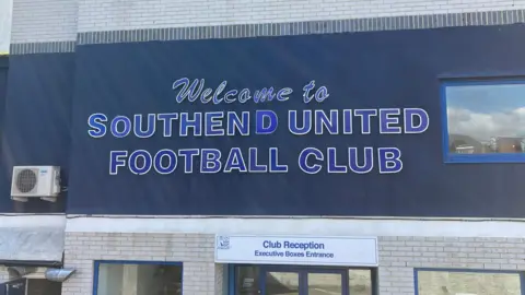 Tom Larsen-Wright/BBC The entrance to the club reception at Roots Hall, which has the lettering "welcome to Southend United Football Club" on the wall above the doors.