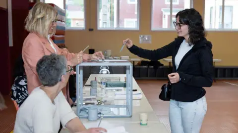 CHANTAL BRIAND/AFP Een kiezer brengt zijn stem uit tijdens de tweede ronde van de Franse parlementsverkiezingen, in een stembureau in Saint-Pierre, in de Franse Noord-Atlantische archipel Saint-Pierre-et-Miquelon