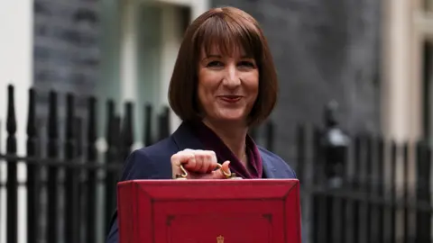 PA Media Chancellor Rachel Reeves holding the red briefcase associated with the Budget announcement as she stands on Downing Street