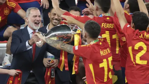 Getty Images King Felipe holds the Euro cup while celebrating with the Spanish men's football team.