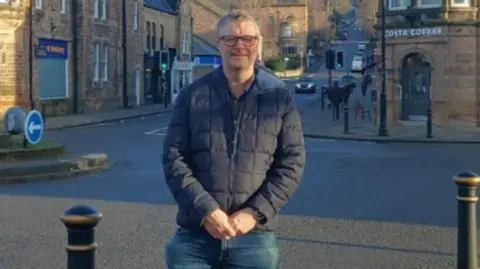 Derbyshire Dales Conservatives Councillor Gareth Gee in front of a Costa Coffee and Card Factory