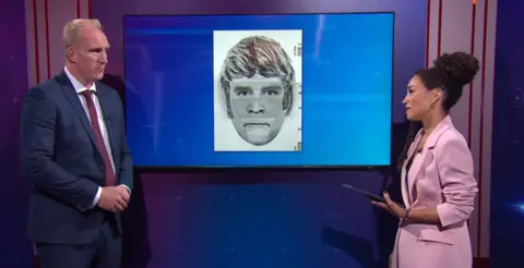 A screenshot from Crimewatch Live where the Det Insp and the presenter discuss an e-fit shown on the screen between them