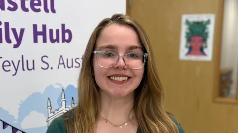 BBC Charlotte Allen-Squire has long light brown hair down past her shoulders and wears glasses and a dark black top. 