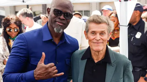 EPA Djimon Hounsou (L) and US actor Willem Dafoe (R) attend the Hollywood Star ceremony for Beninese singer and five-time Grammy Award winner Angelique Kidjo