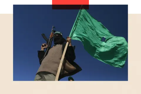 AFP via Getty Images A Hamas militant waves his party's flag
