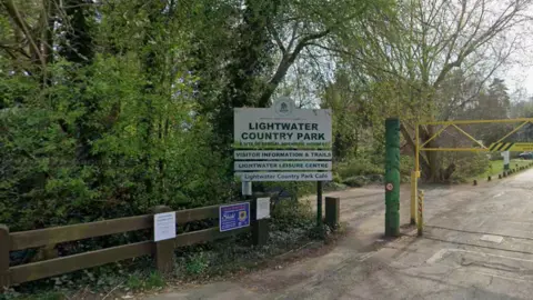 Google A sign says 'LIGHTWATER COUNTRY PARK, VISITOR INFORMATION & TRAILS, LIGHTWATER LEISURE CENTRE, Lightwater Country Park Cafe.'