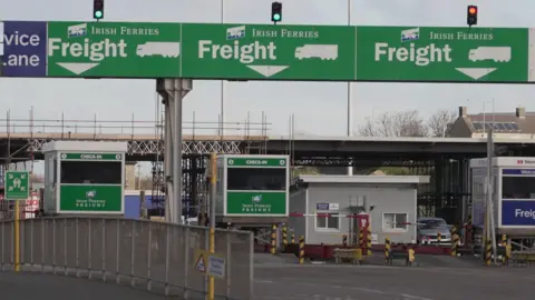 Tanda BBC Green di atas loket terminal feri dengan tulisan Irish Ferries and Freight ditulis dengan tulisan putih 