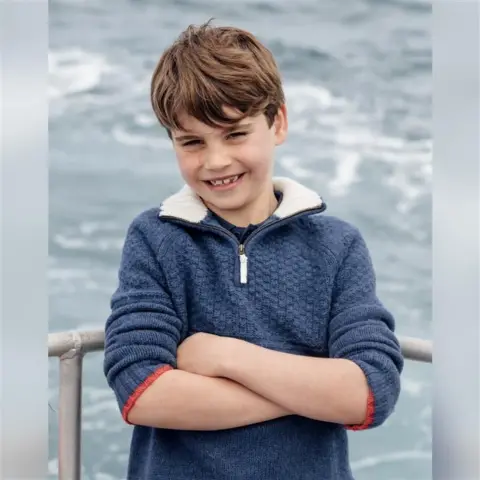 Matt Porteous A grinning Louis is shown leaning with his arms folded against a metal barrier, with the sea as the backdrop.