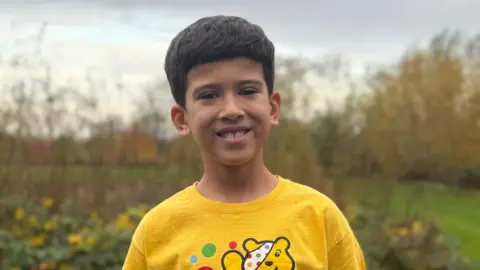 Supplied Andre smiling at the camera wearing a Children in Need top