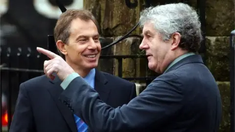 Tony Blair and Rhodri Morgan in conversation with Morgan pointing to the distance