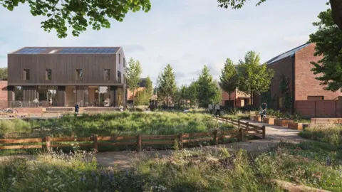 A large brown building covered in solar panels stands in a landscaped area with trees, paths, grass and fencing. A brick building is on the right hand side under a blue sky.