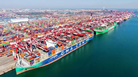 Cargo ships load and unload foreign trade containers at the fully automated terminal of Qingdao Port in China.