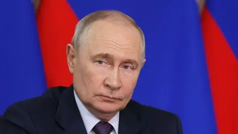 Putin looking at a distance, wearing a dark coloured suit